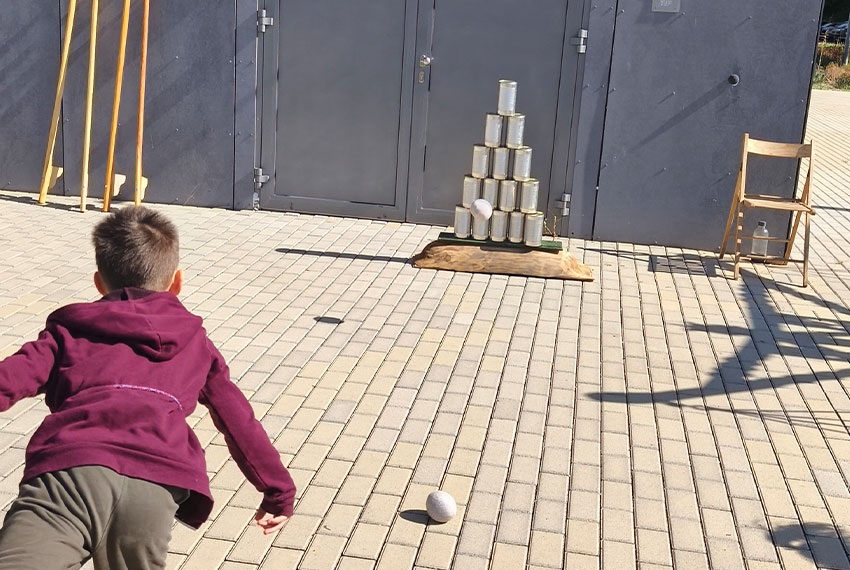 Áram nélkül működő fa játékok és környezetbarát népi játszótér egy szabadtéri céges rendezvényen.