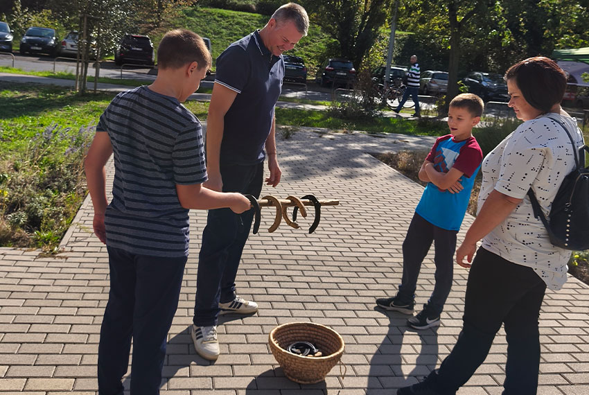 Családok és gyerekek önfeledten játszanak a Csemetekert bérelhető fajátékaival egy céges családi napon, ahol a szórakozás ingyenes.