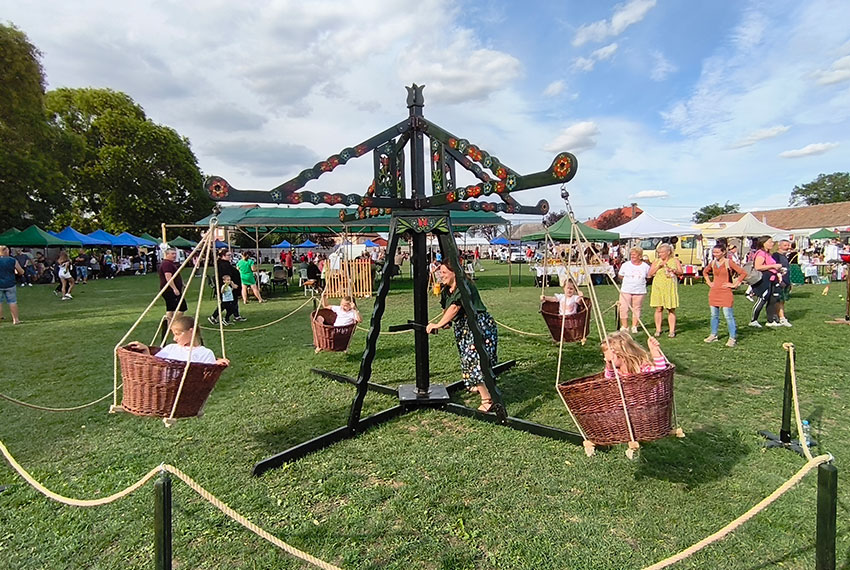 Népi kosaras körhinta gyerekekkel, emberi erővel hajtott látványos fajáték falunapon.
